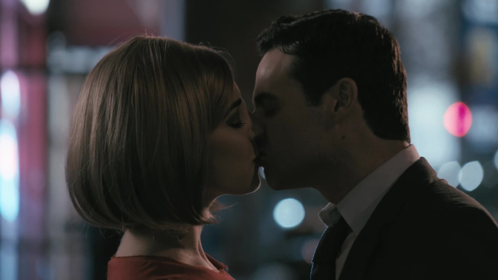 Blonde and The Man kiss on a city street